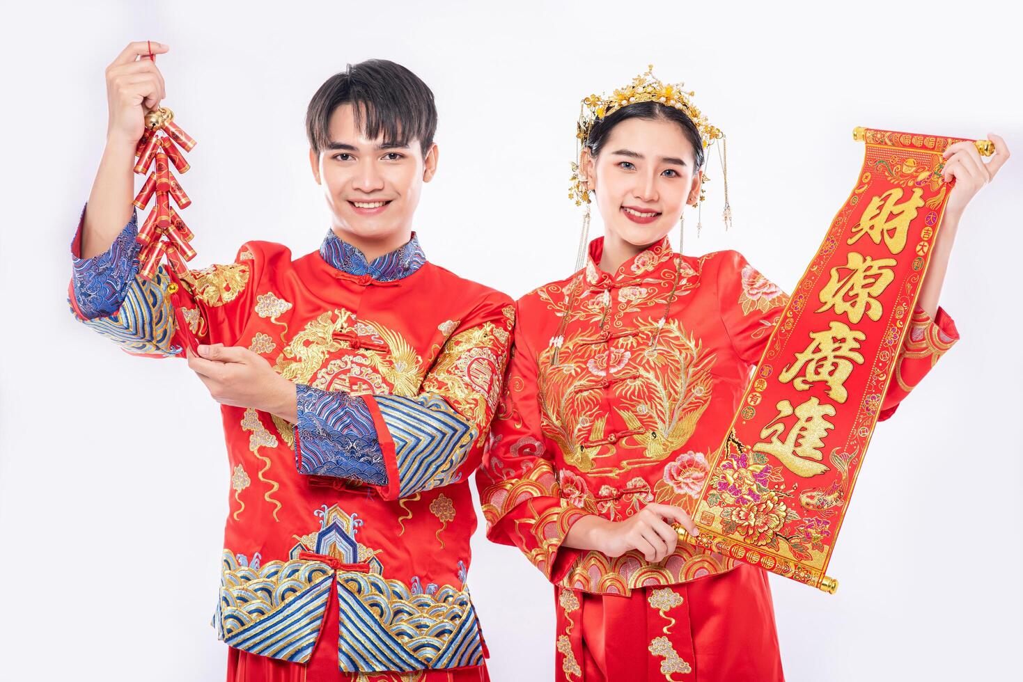 l'uomo e la donna indossano un abito cheongsam promuovono biglietti di auguri cinesi e petardi da utilizzare nel capodanno cinese foto