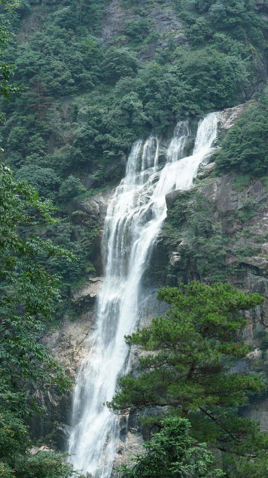 la bellissima vista sulla campagna con la cascata che scorre in montagna dopo la giornata di pioggia foto