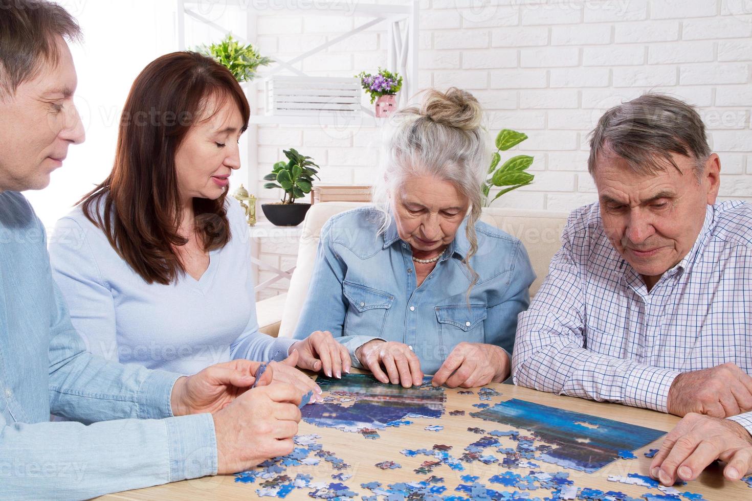 famiglia che completa il puzzle insieme a casa con il puzzle foto