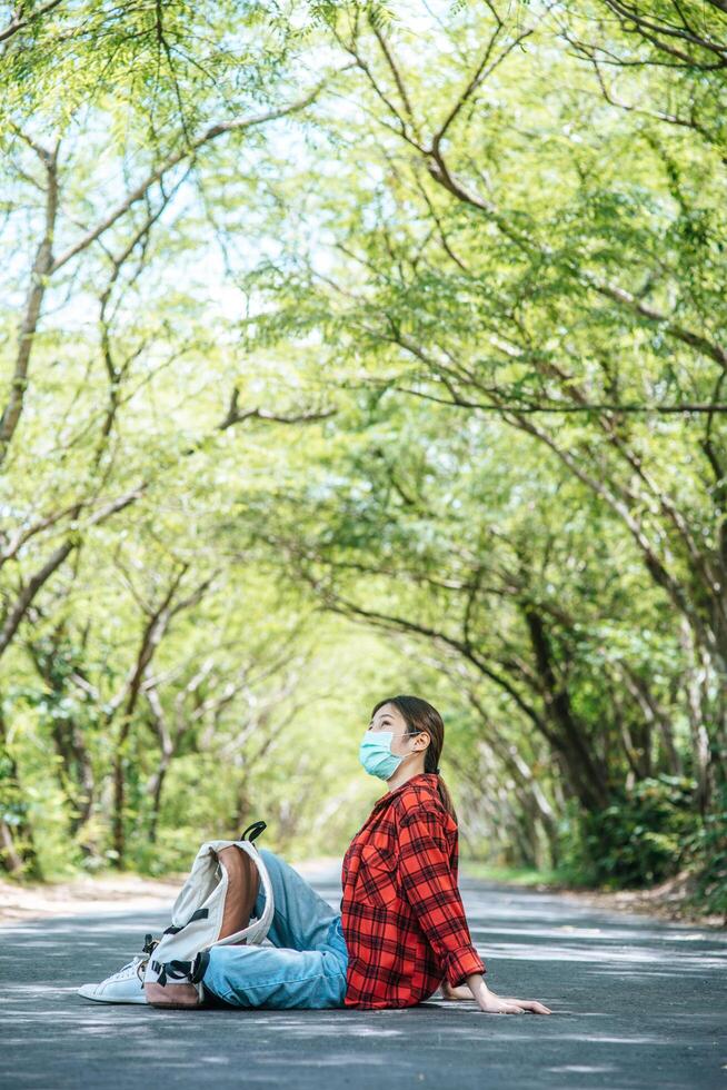 turiste che indossano una maschera per sedersi e rilassarsi per strada. foto