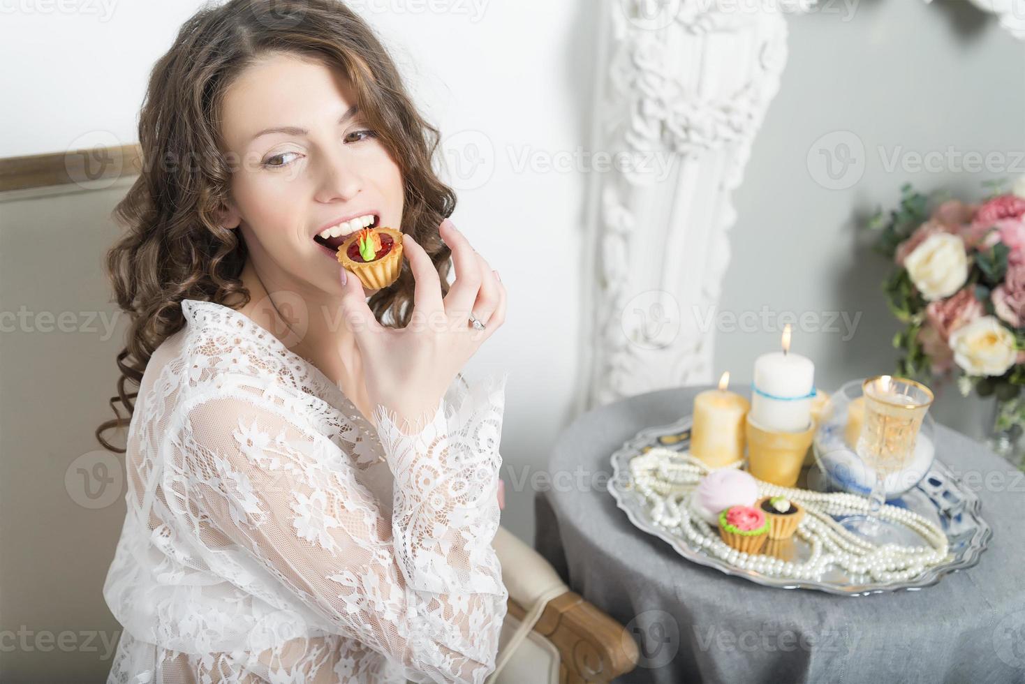 la ragazza al tavolo seduta e mangiare i biscotti. foto