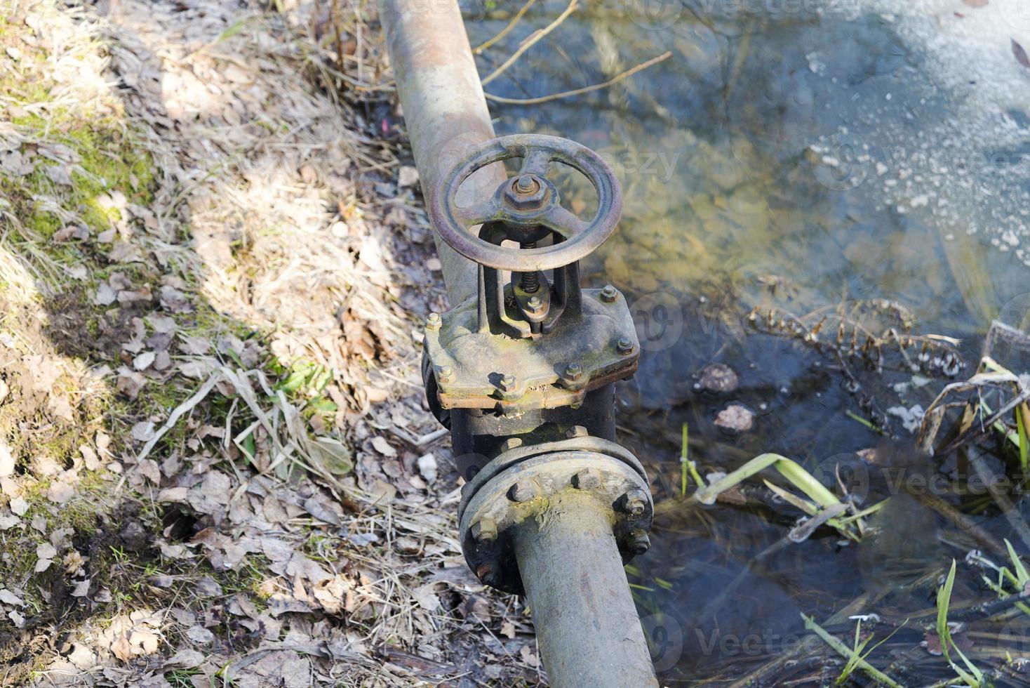 la valvola sul tubo vicino al fiume. foto