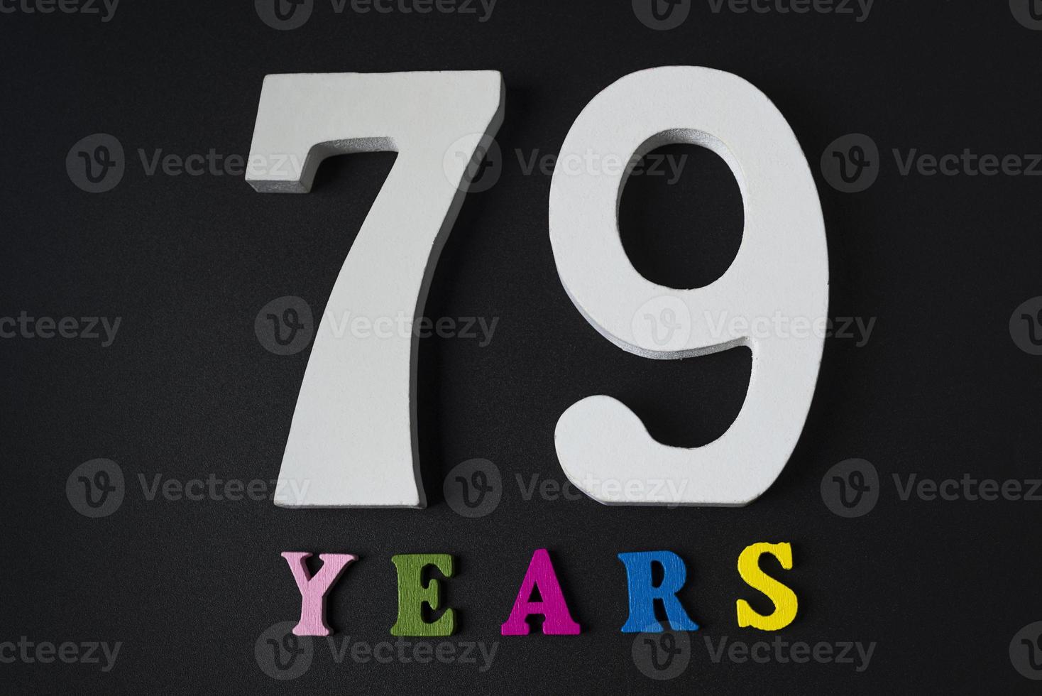 lettere e numeri settantanove anni su sfondo nero. foto