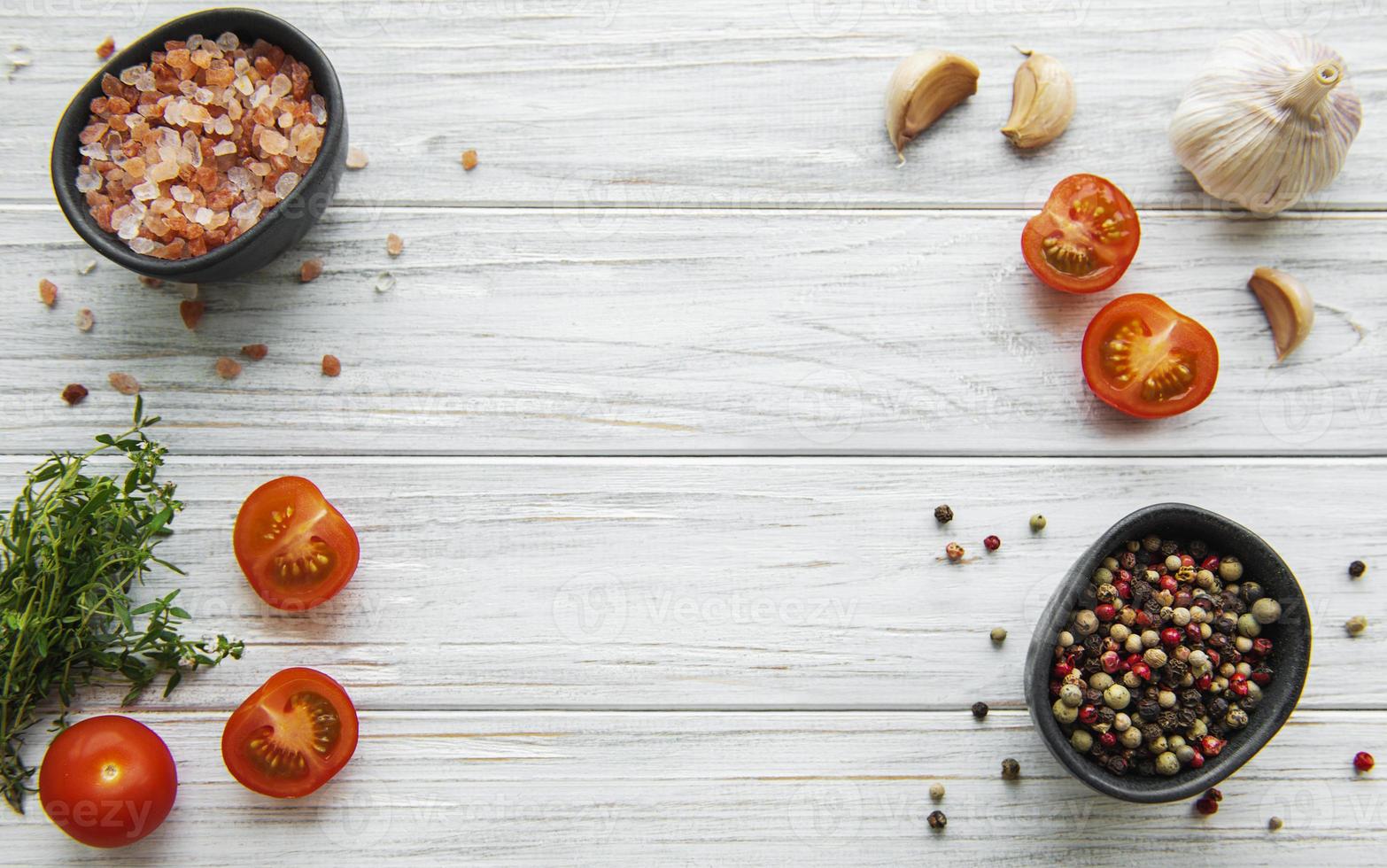 pomodoro, basilico e pepe con aglio su fondo di legno bianco foto