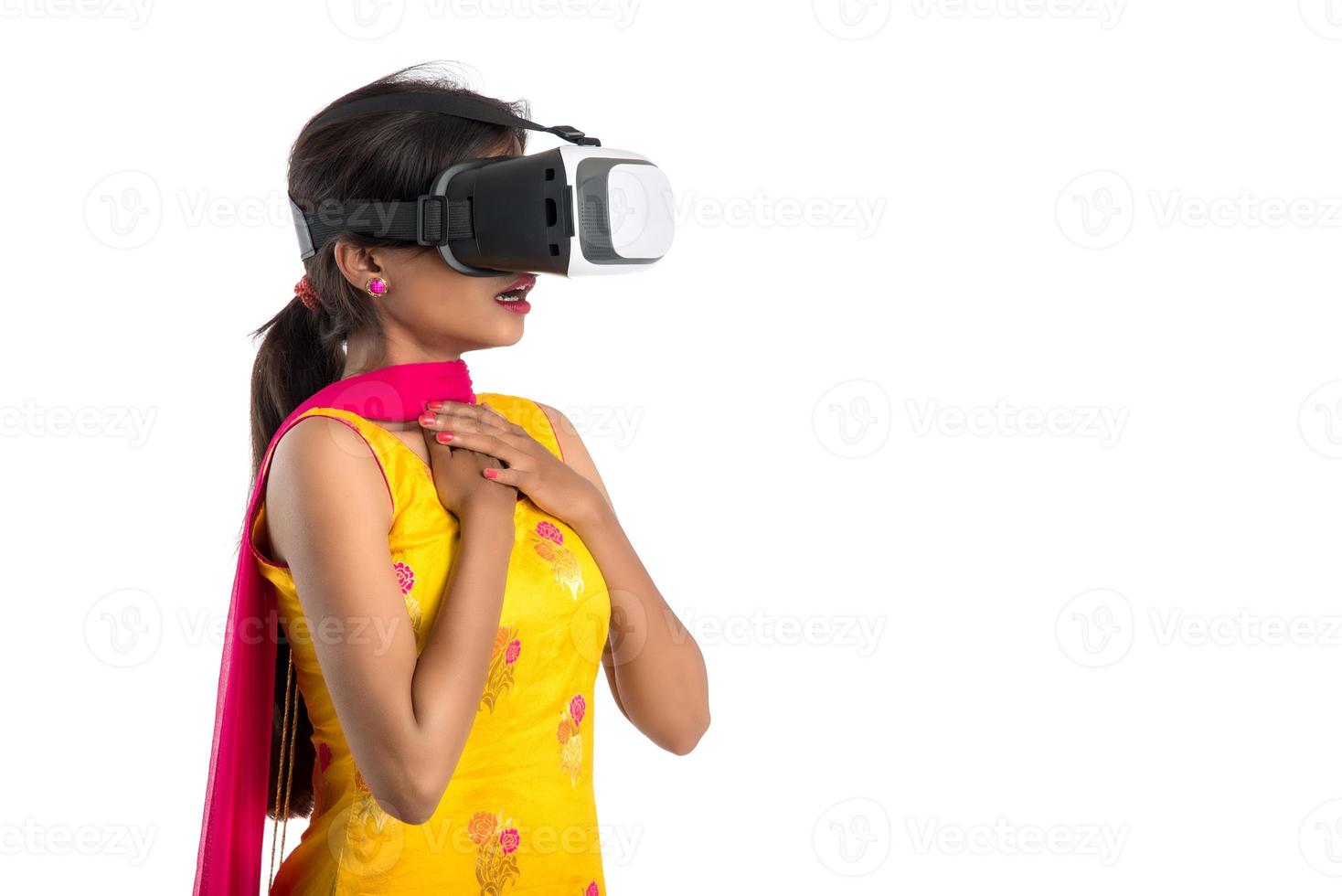 ragazza tradizionale indiana che tiene e mostra dispositivo vr, scatola vr, occhiali, cuffie per occhiali per realtà virtuale 3d, ragazza con moderna tecnologia futura di imaging su sfondo bianco. foto