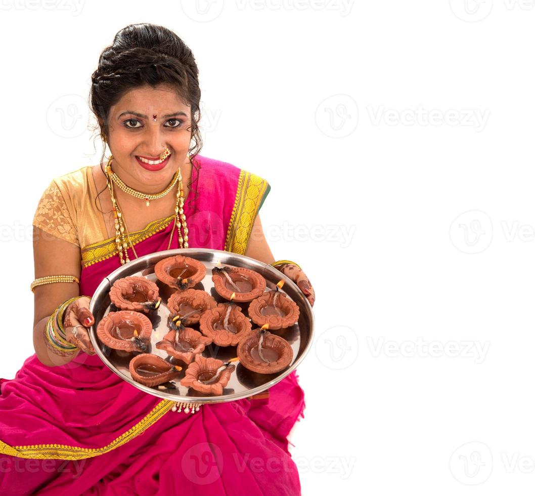ritratto di una ragazza tradizionale indiana che tiene in mano diya, diwali o deepavali foto con mani femminili che tengono lampada a olio durante il festival della luce su sfondo bianco