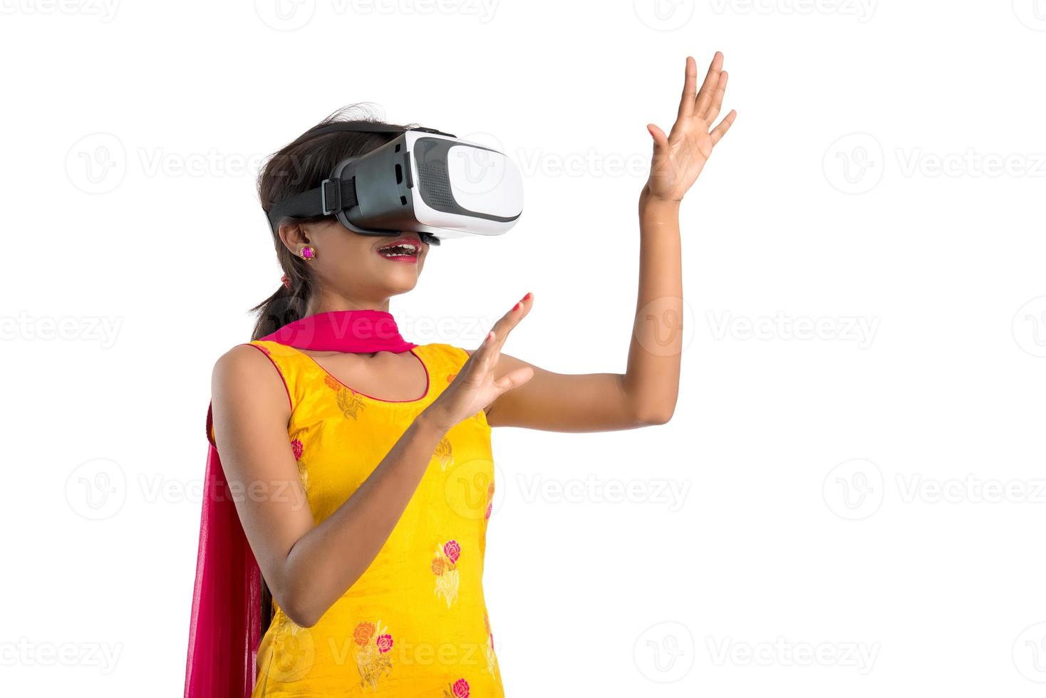 ragazza tradizionale indiana che tiene e mostra dispositivo vr, scatola vr, occhiali, cuffie per occhiali per realtà virtuale 3d, ragazza con moderna tecnologia futura di imaging su sfondo bianco. foto