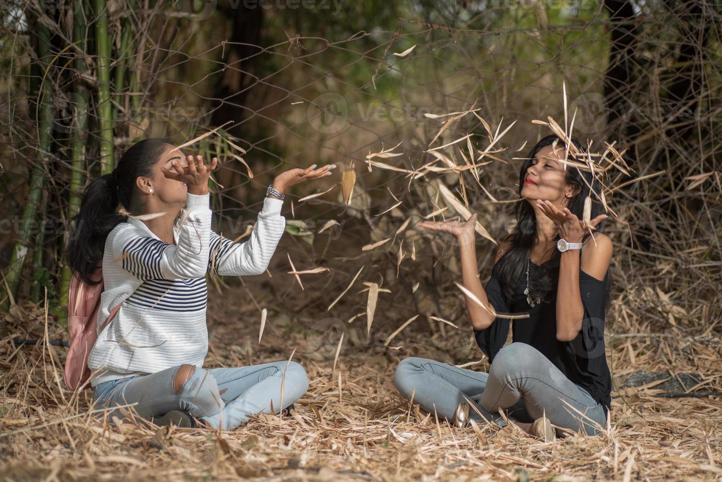 ragazze felici che giocano con le foglie cadute nel parco foto