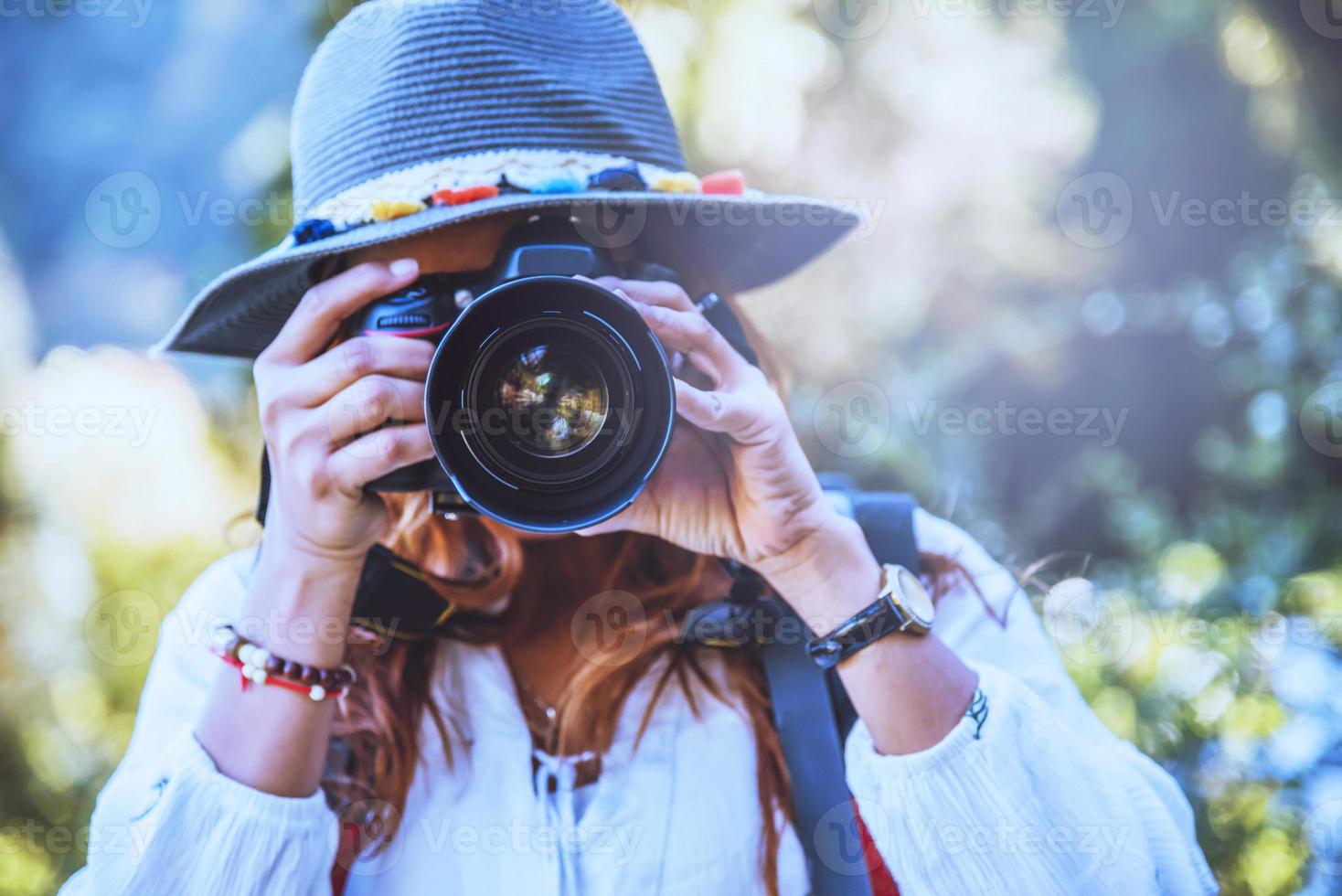 fotografo donne asiatiche viaggiano nella natura. viaggiare rilassati. studio della natura. al parco pubblico in estate. in Thailandia foto