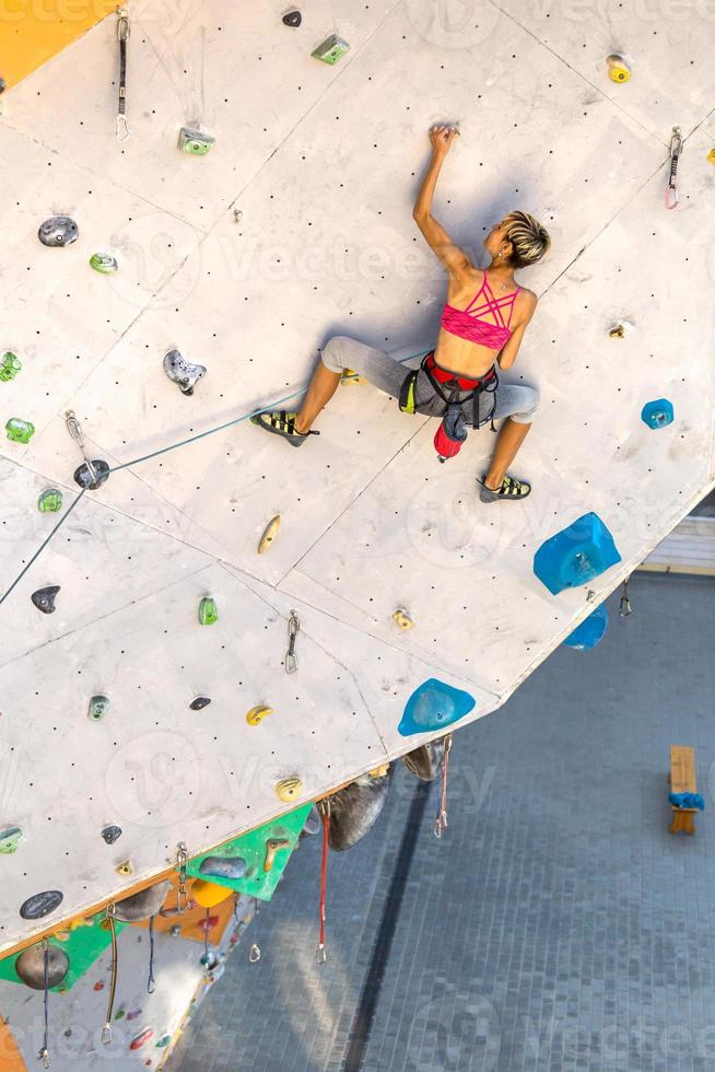 una donna sta scalando una parete da arrampicata foto