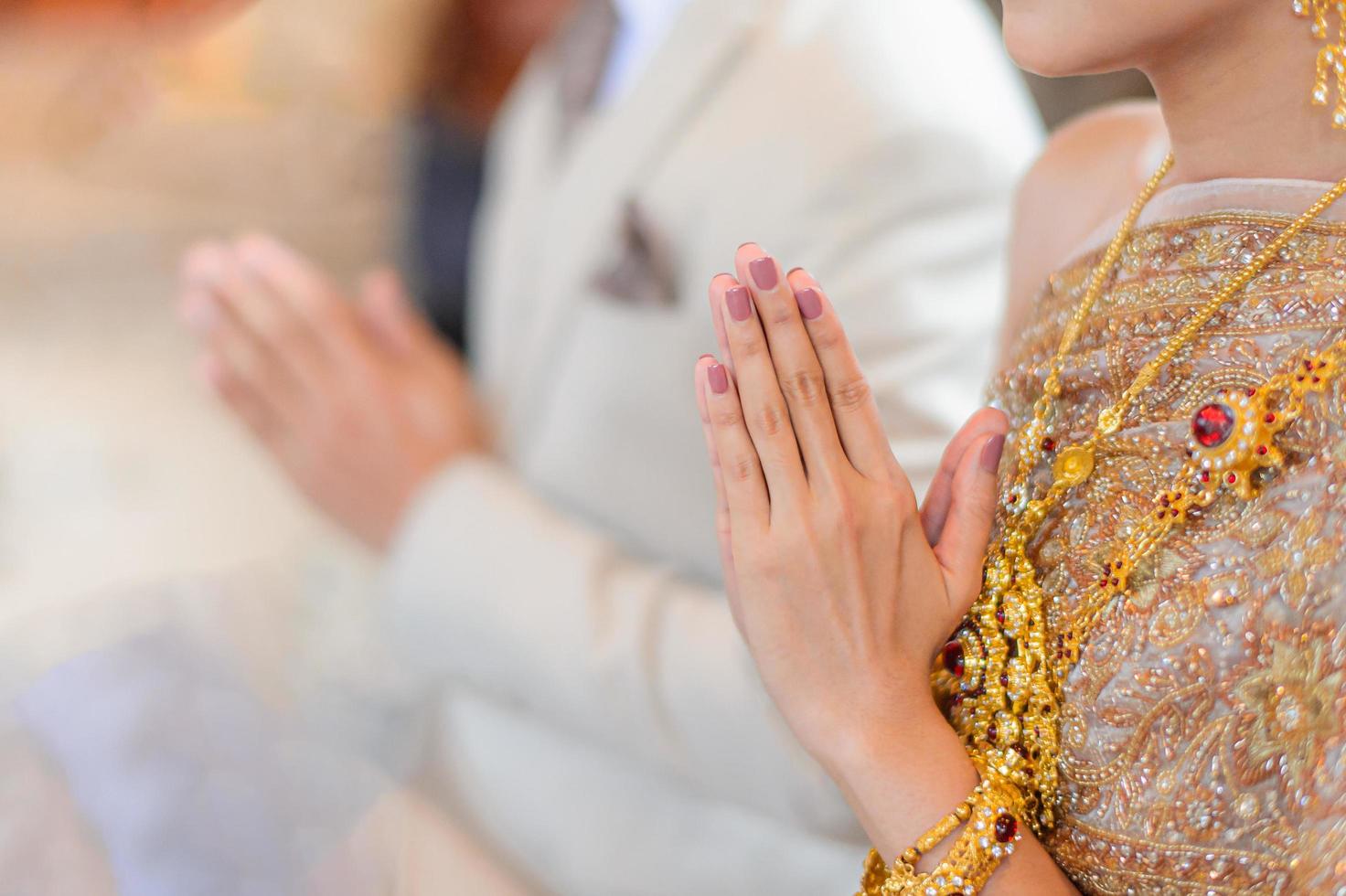 saluto tradizionale tailandese con le mani dello sposo e della sposa, cerimonia di fidanzamento del matrimonio tailandese foto