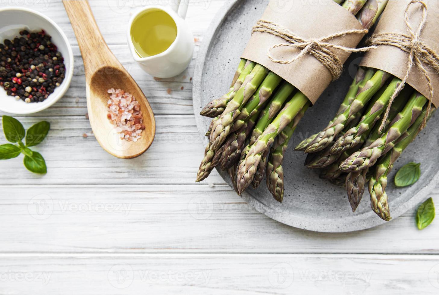 mazzo di gambi di asparagi crudi con spezie diverse foto