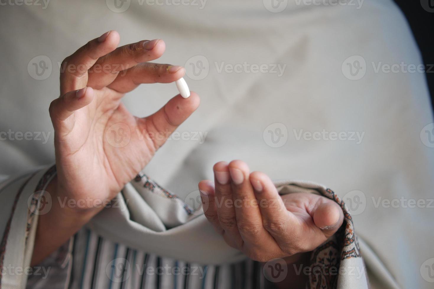 Pillole della tenuta della mano dell'uomo malato con lo spazio della copia foto