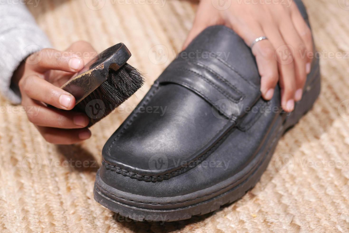 pulire le scarpe con una spazzola sul pavimento foto