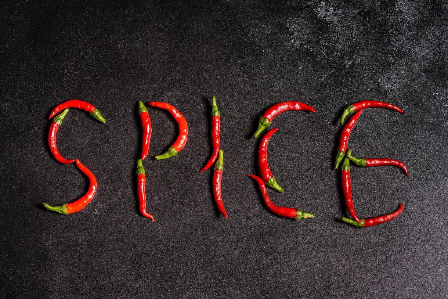 peperoncino rosso brillante su sfondo grigio cemento. cibo piccante, ingredienti foto