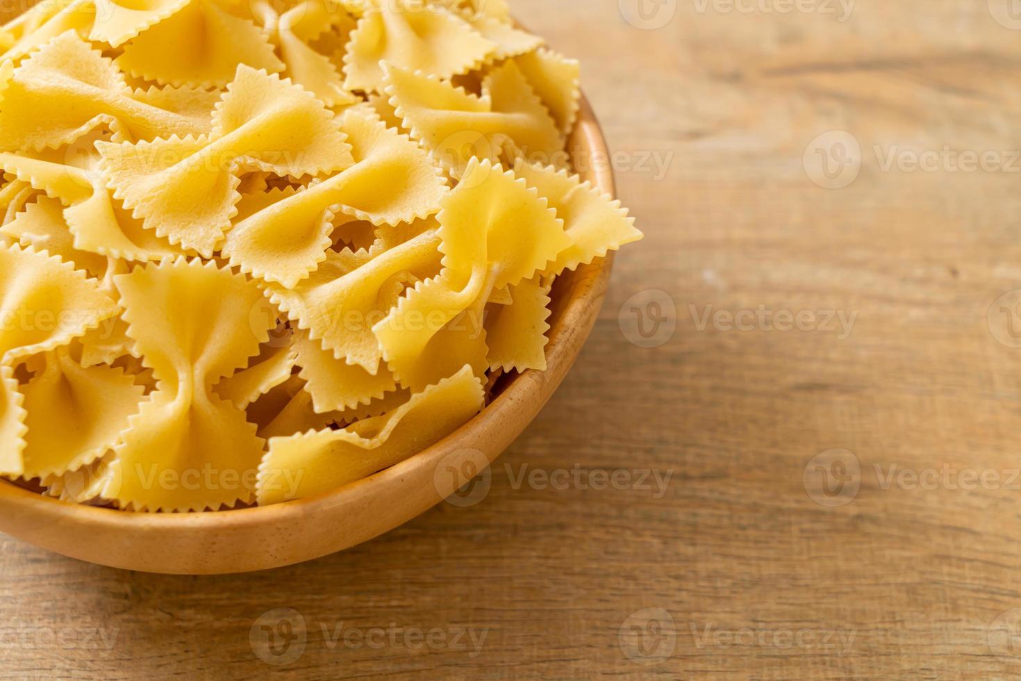 pasta secca di farfalle crude in una ciotola foto