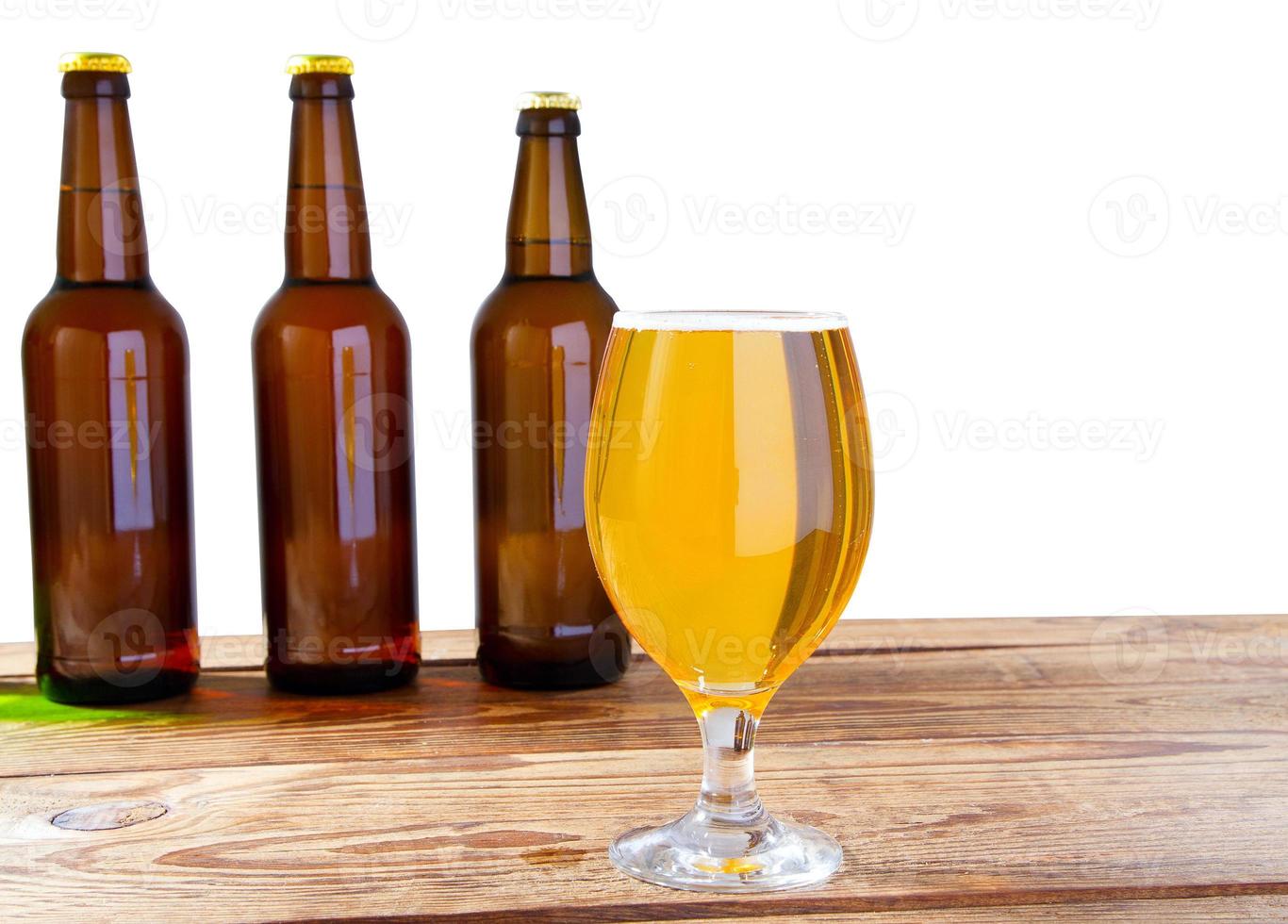 bicchiere di birra e bottiglie senza logo sul tavolo di legno spazio copia isolato, bottiglia di vetro foto
