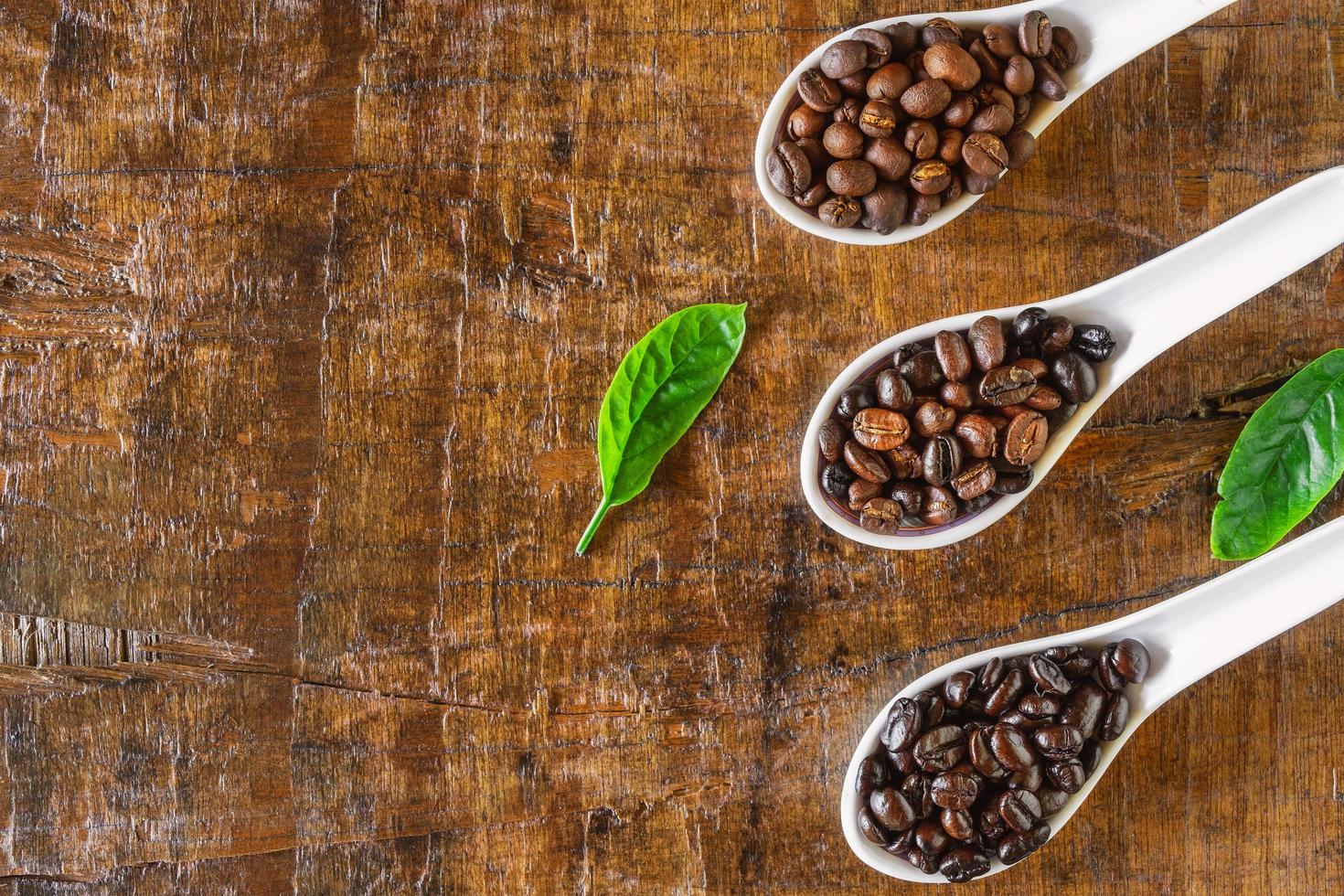 un collage di chicchi di caffè in cucchiaio che mostra le varie fasi fino alla tostatura foto