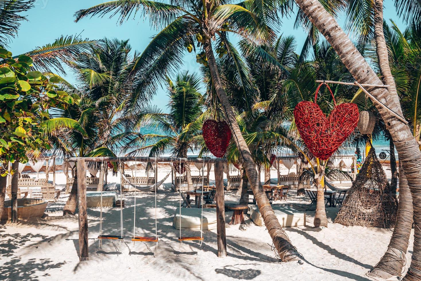 altalena vuota con oggetto a forma di cuore appeso all'albero al resort sulla spiaggia foto