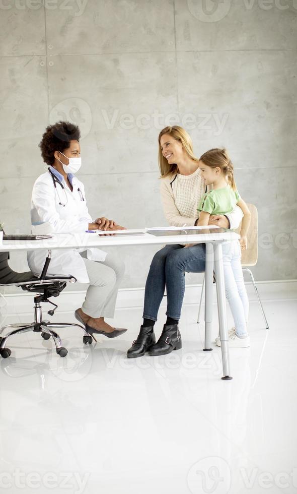 bambina carina con sua madre all'esame del pediatra foto