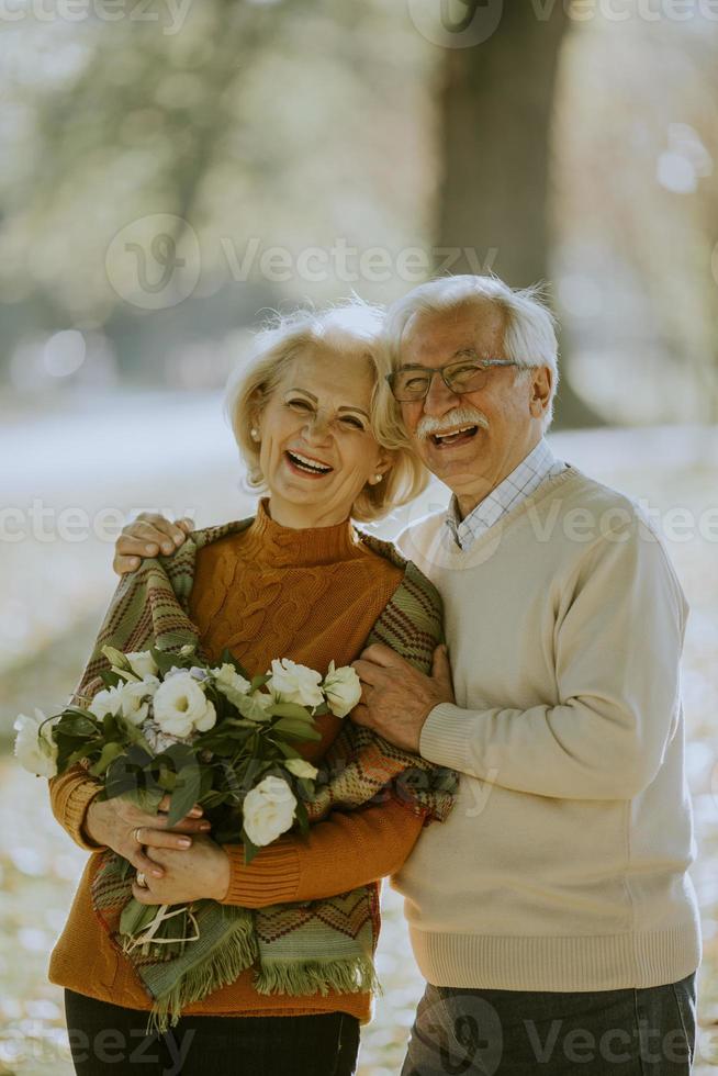 coppia senior con bouquet di fiori nel parco autunnale foto