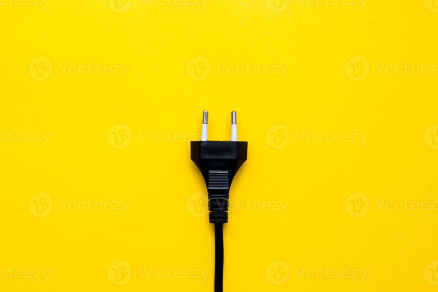 connettore elettrico nero su sfondo giallo. vista dall'alto. copia, spazio vuoto per il testo foto