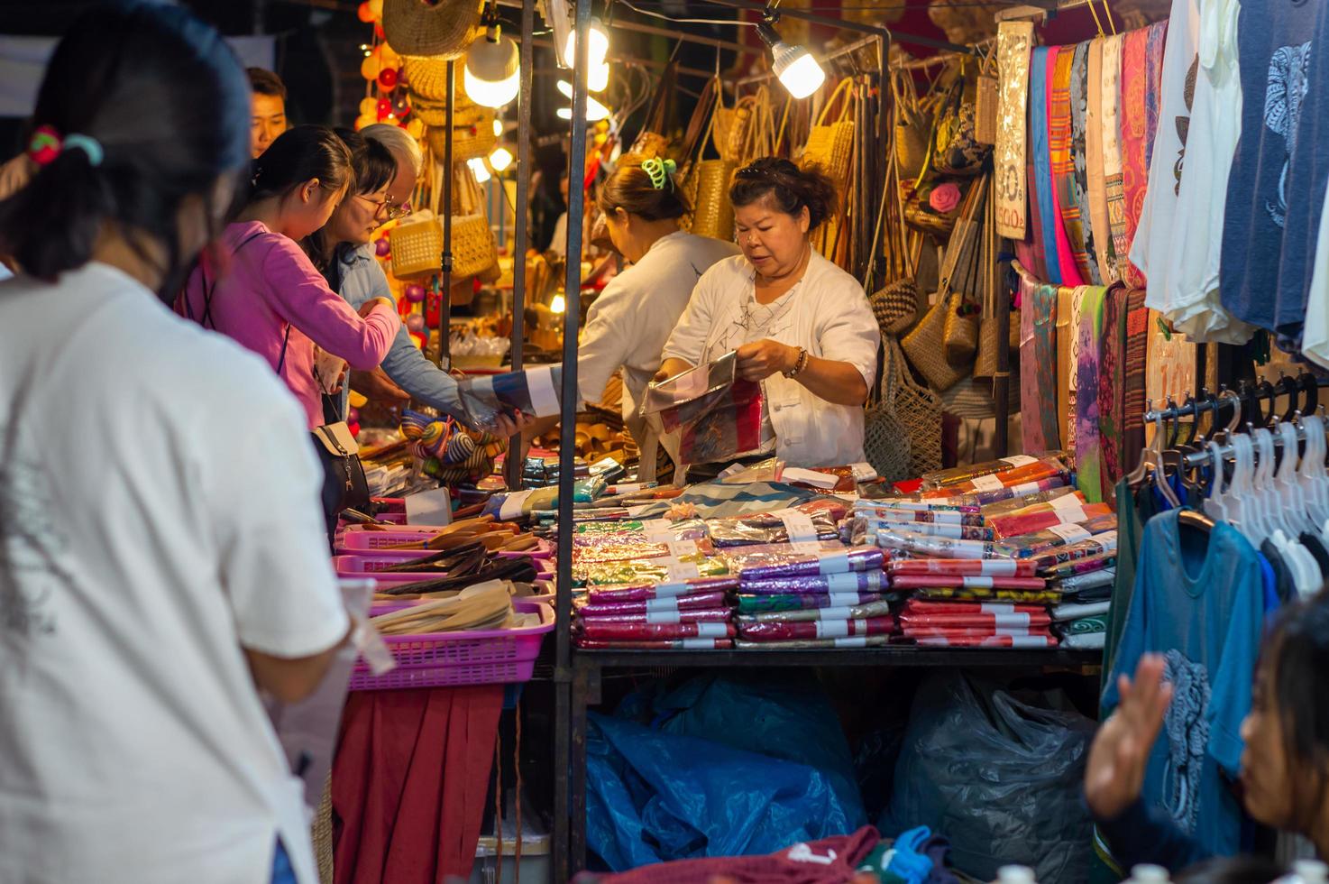 chiang mai walking street chiang mai thailand12 gennaio 2020un mercato di artigianato locale fatto di setaceramicametallovetrolegno o arte e cibo i turisti thailandesi e gli stranieri amano passeggiare e fare shopping foto