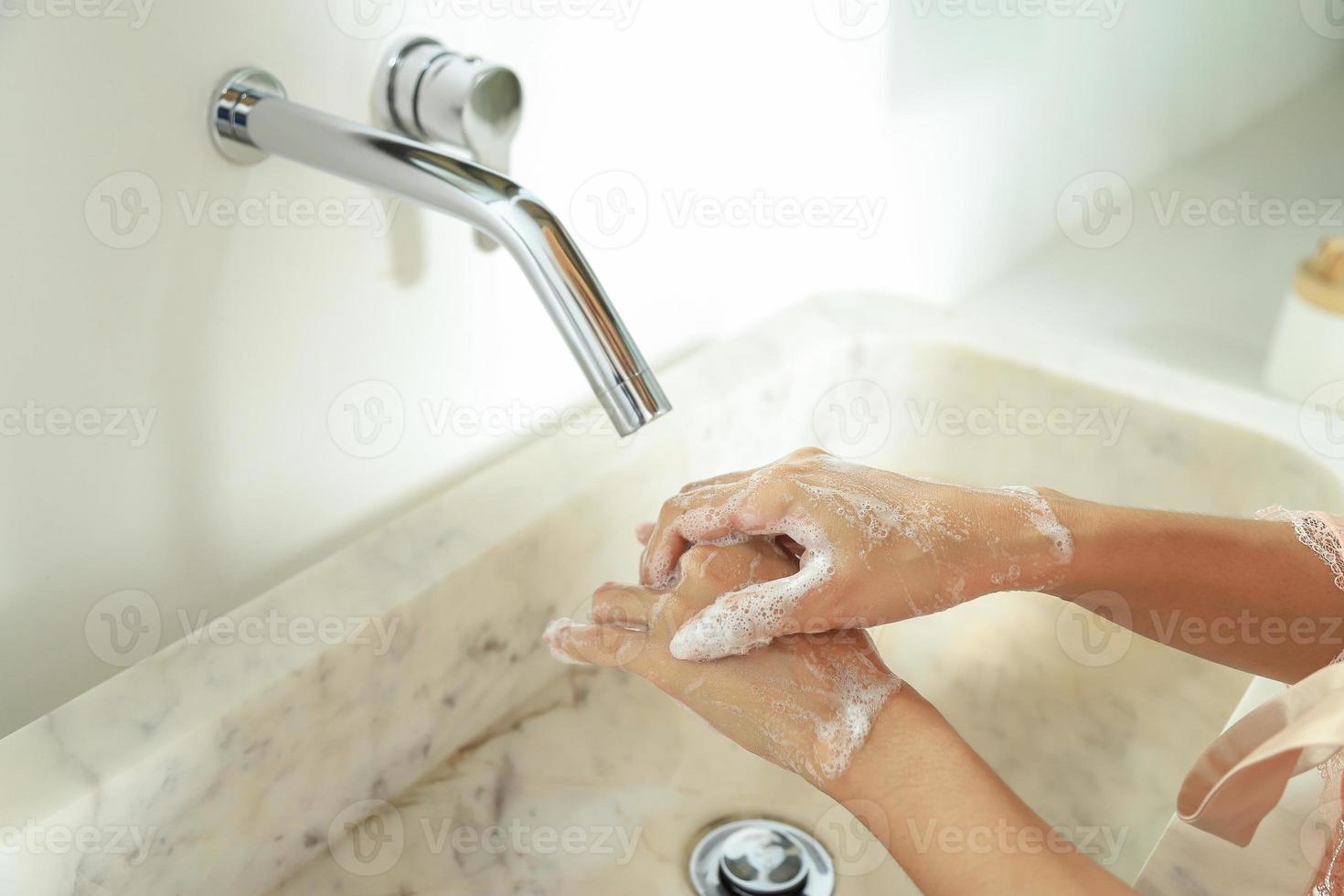 pulire le mani con sapone nel lavandino per lo stile di vita della vita sanitaria foto