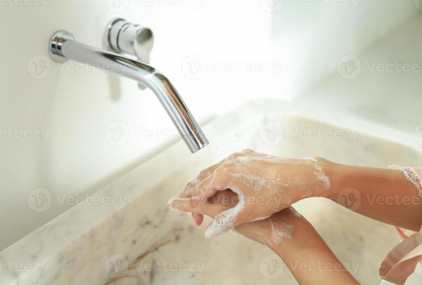 pulire le mani con sapone nel lavandino per lo stile di vita della vita sanitaria foto