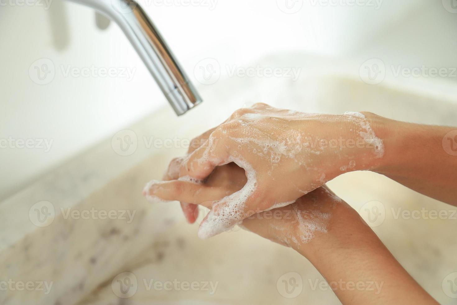 pulire le mani con sapone nel lavandino per lo stile di vita della vita sanitaria foto