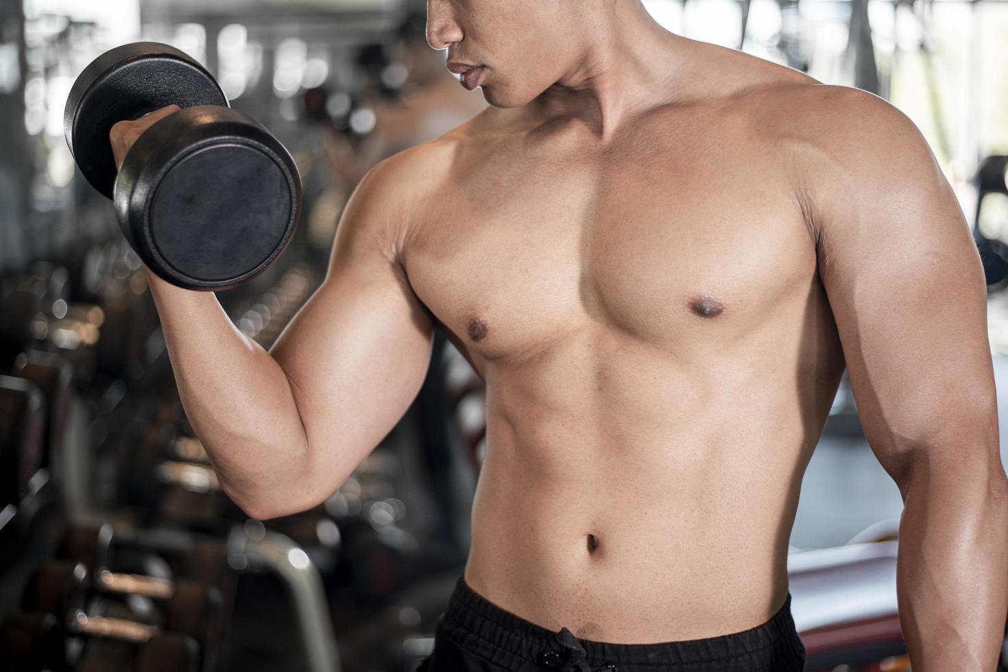 primo piano uomo muscoloso è esercizio in palestra foto