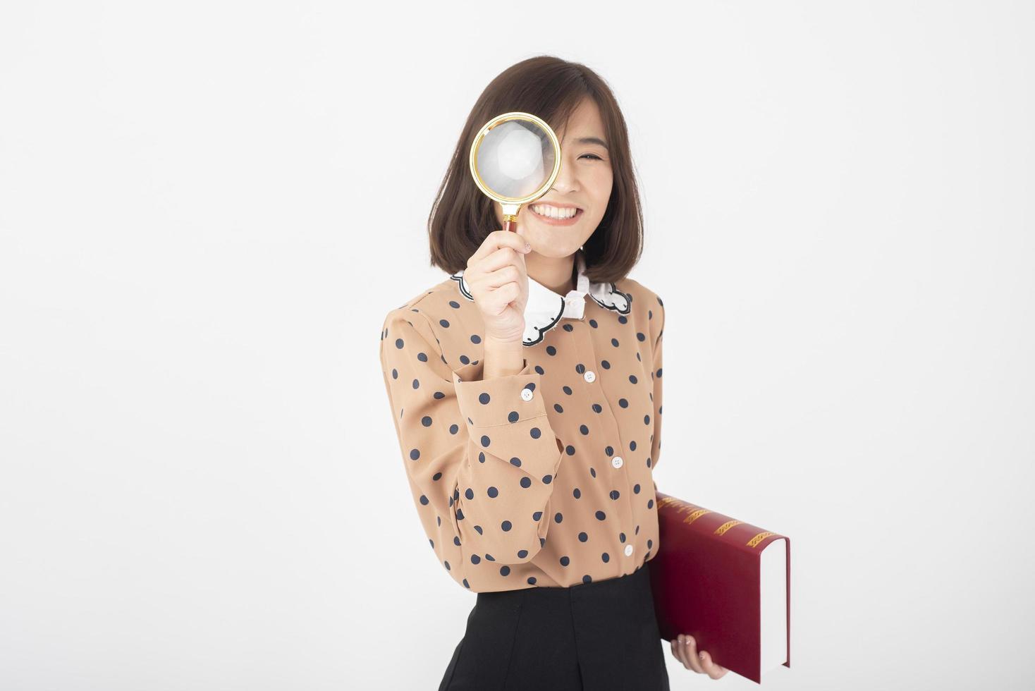 attraente donna asiatica sta tenendo un libro su sfondo bianco foto