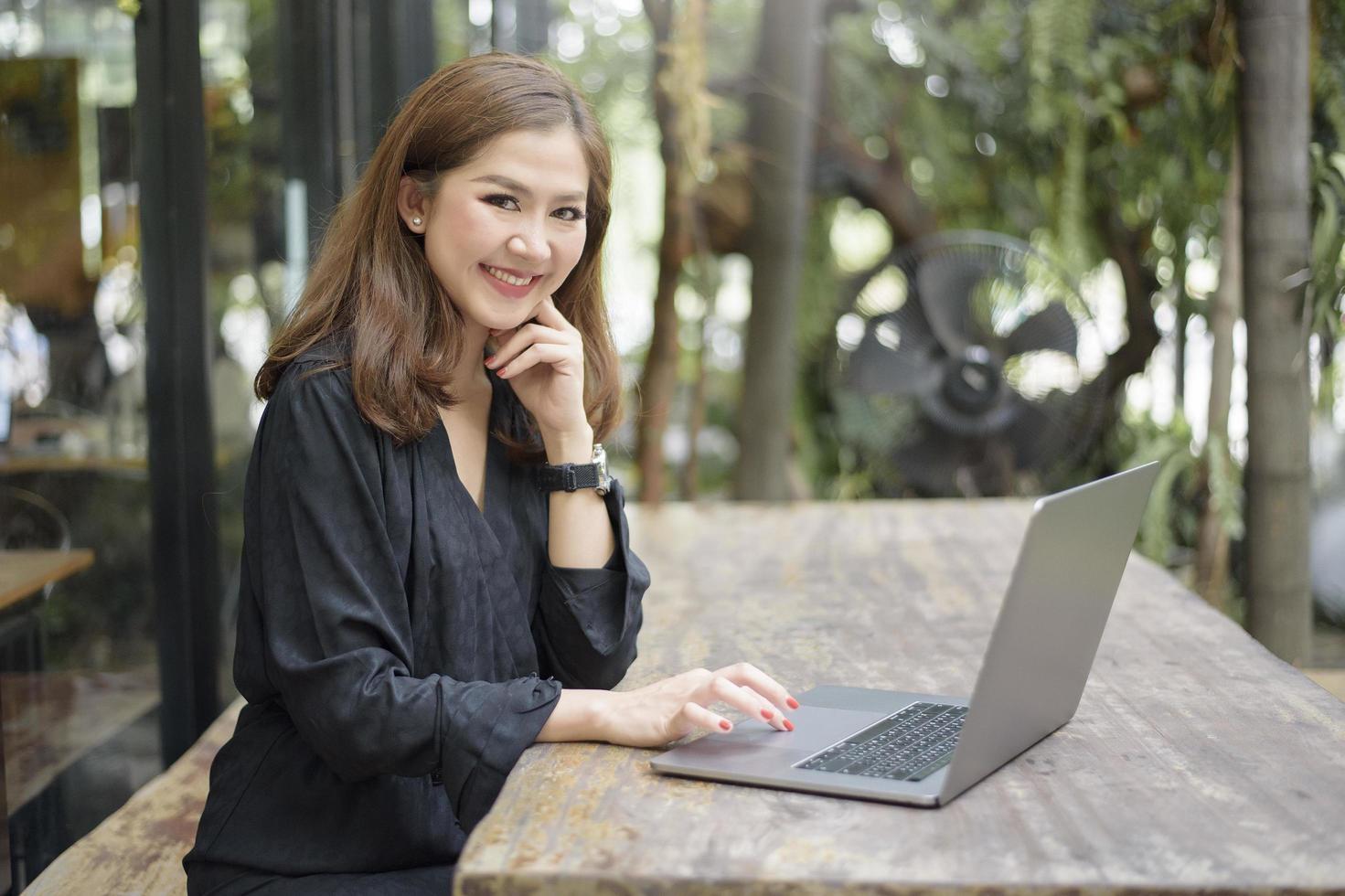 la femmina asiatica intelligente sta lavorando con il computer portatile foto