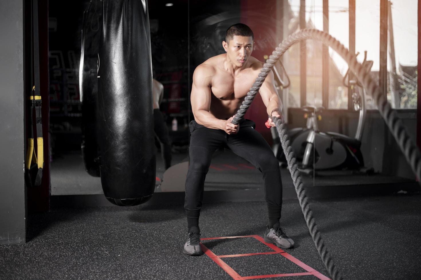 un uomo è esercizio con la corda in palestra foto