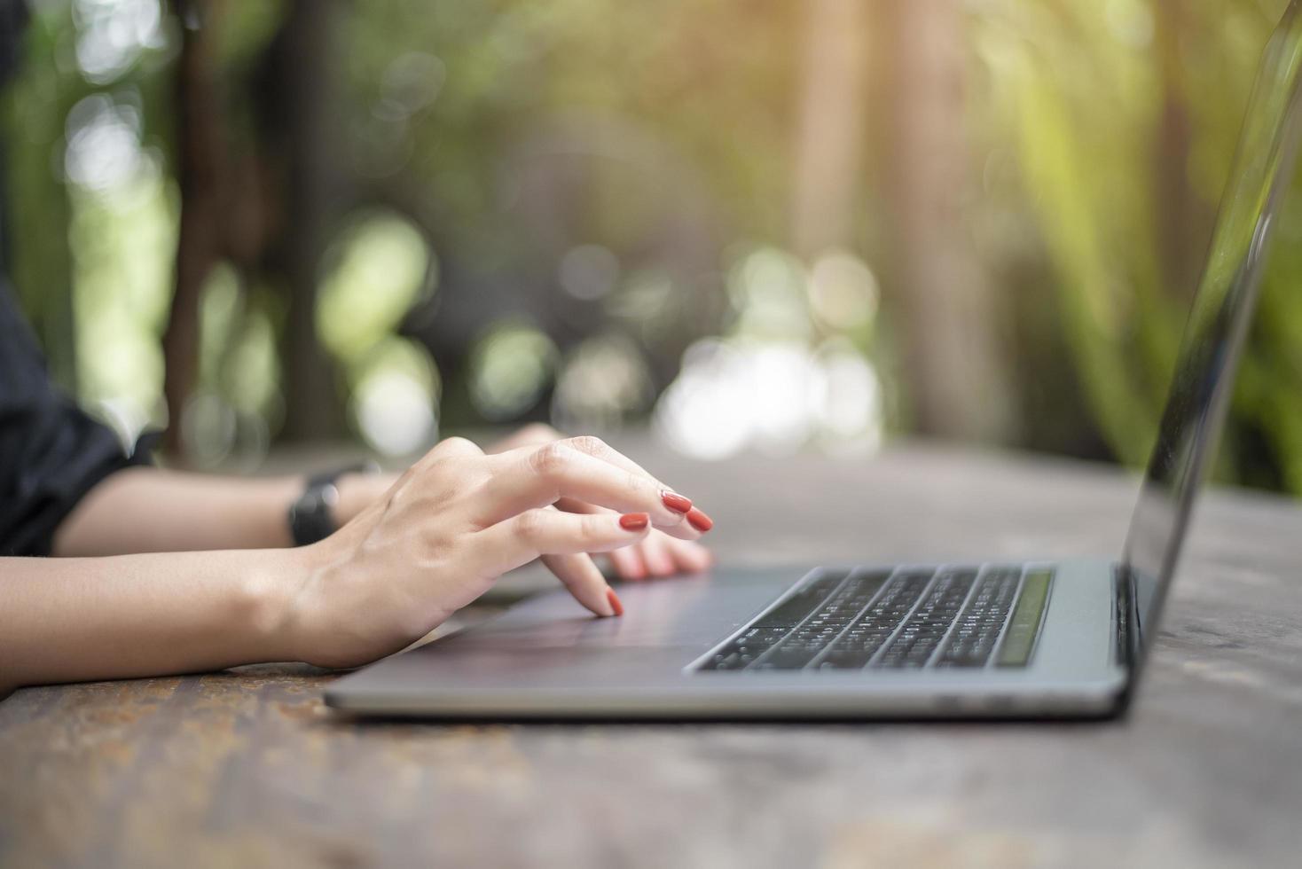 vicino la mano femminile sul computer portatile foto