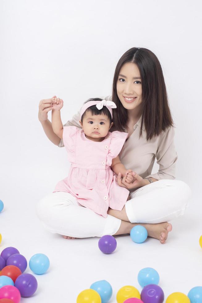 la madre asiatica e la neonata adorabile sono felici su fondo bianco foto