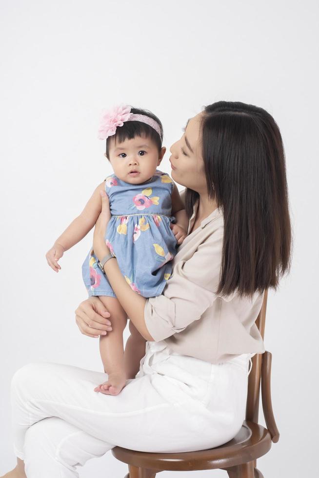 la madre asiatica e la neonata adorabile sono felici su fondo bianco foto