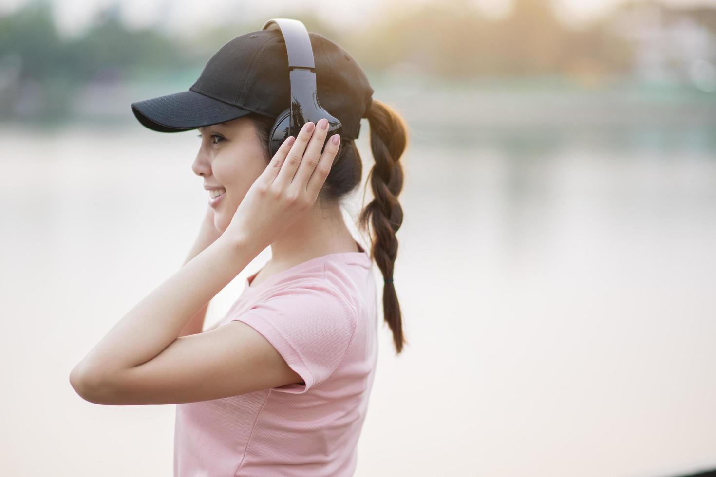 bella donna sta ascoltando musica nel parco foto