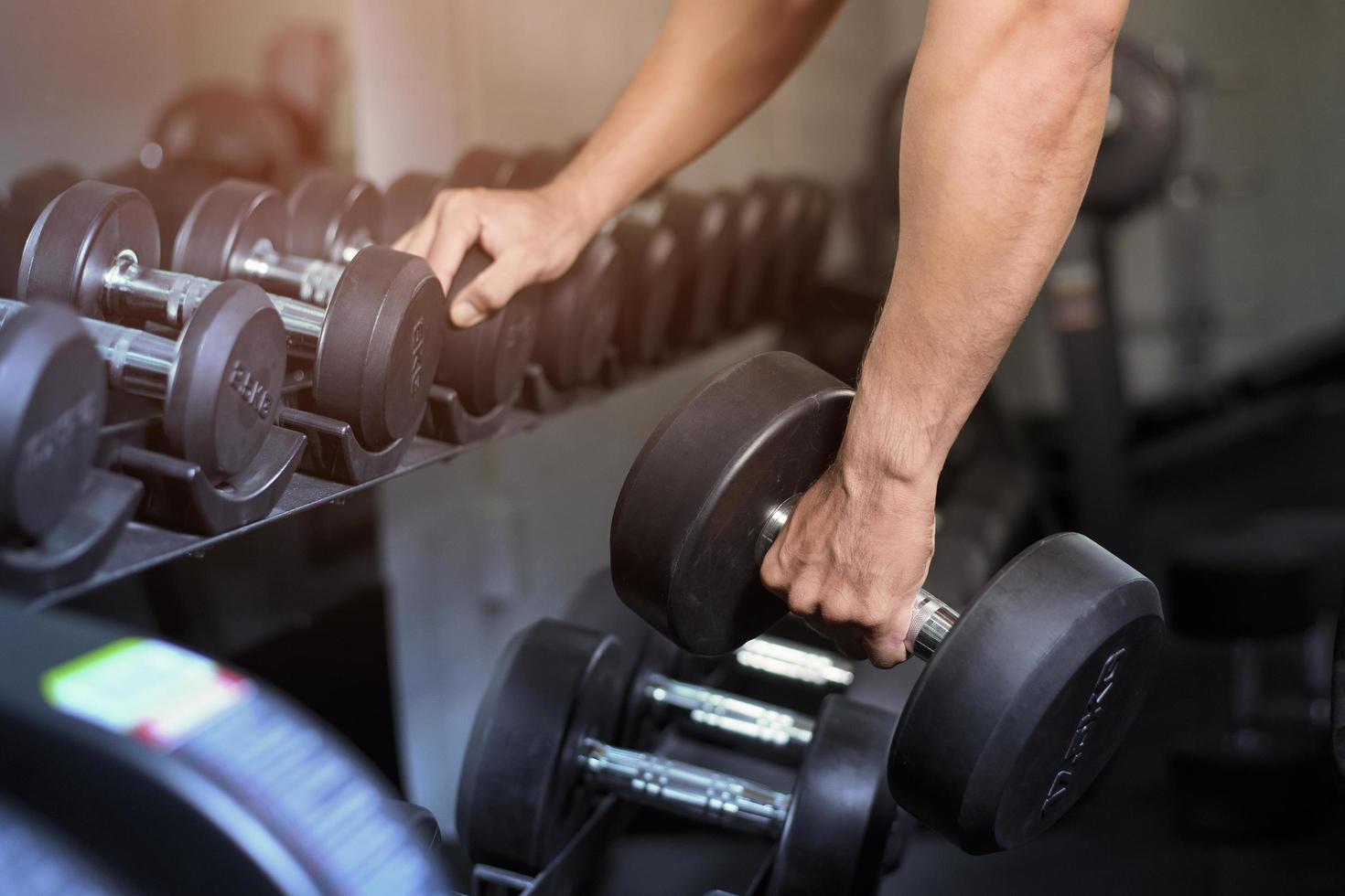 bodybuilder uomo fitness muscolare è allenamento con manubri in palestra foto