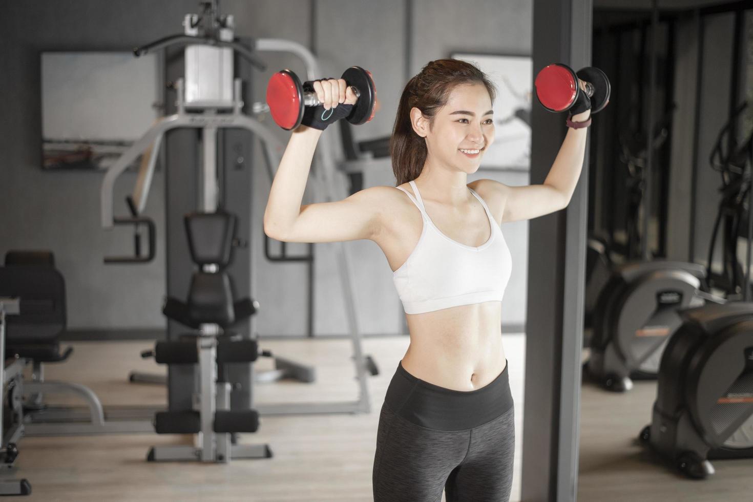 bella donna asiatica sta facendo esercizio in palestra foto