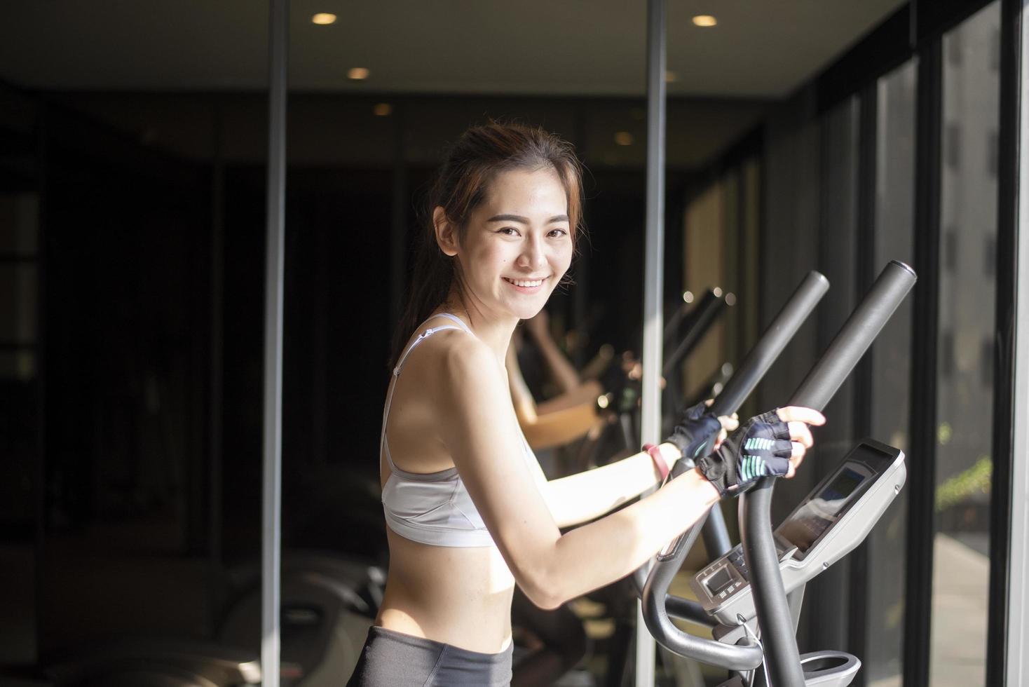 bella donna asiatica sta facendo esercizio in palestra foto