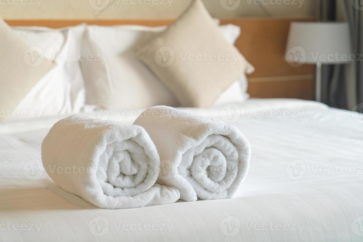 asciugamano bianco sul letto in camera da letto foto