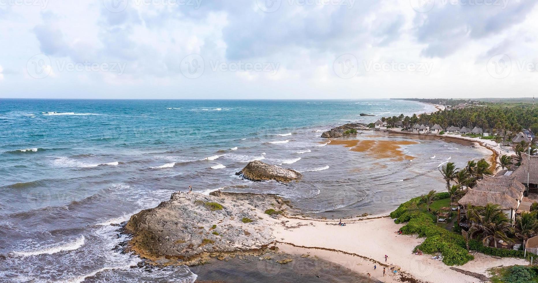 costa aerea di tulum sulla spiaggia con un magico mare caraibico e piccole capanne sulla costa. foto