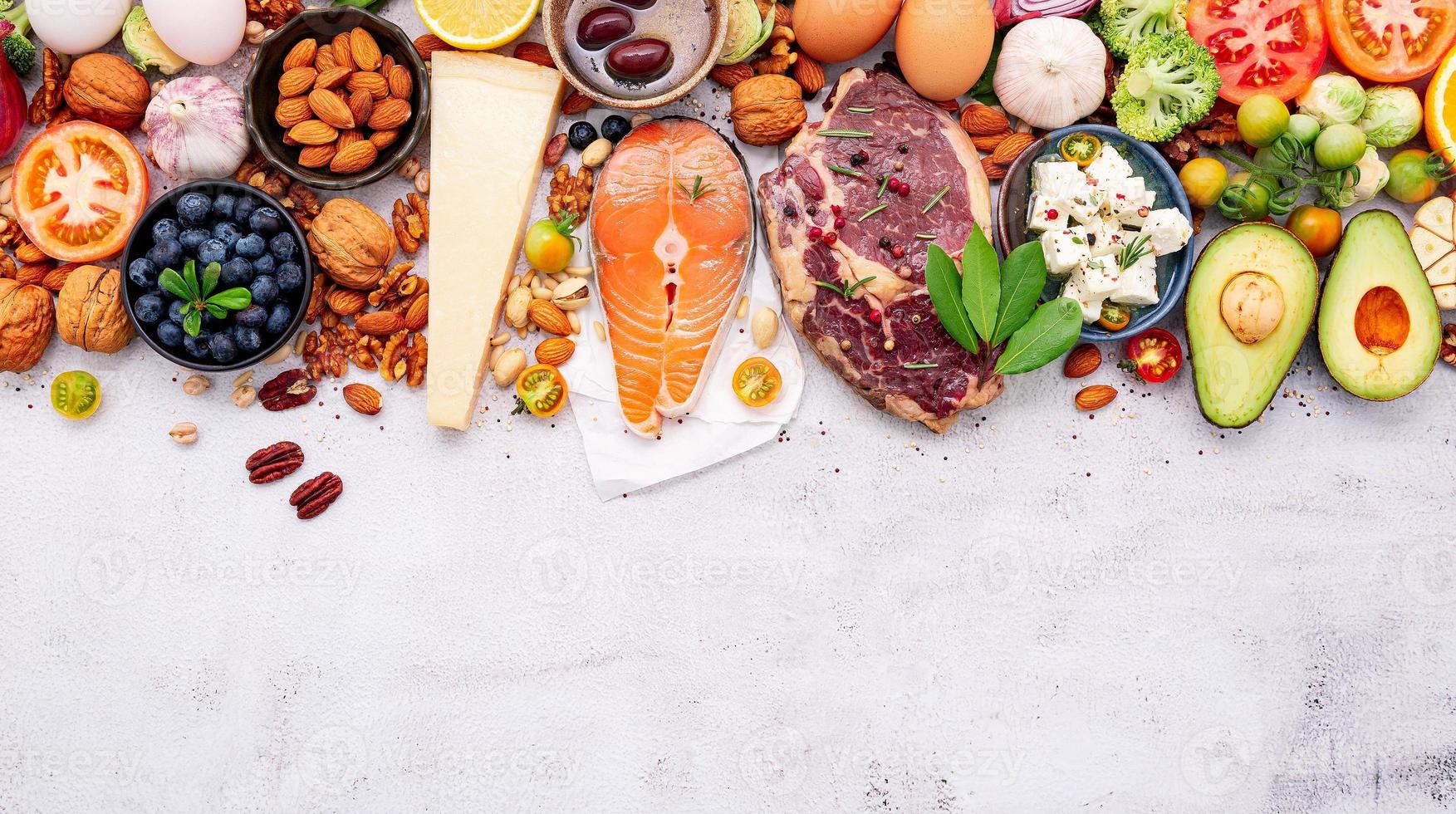 concetto di dieta chetogenica a basso contenuto di carboidrati. ingredienti per la selezione di cibi sani impostati su sfondo bianco di cemento. foto