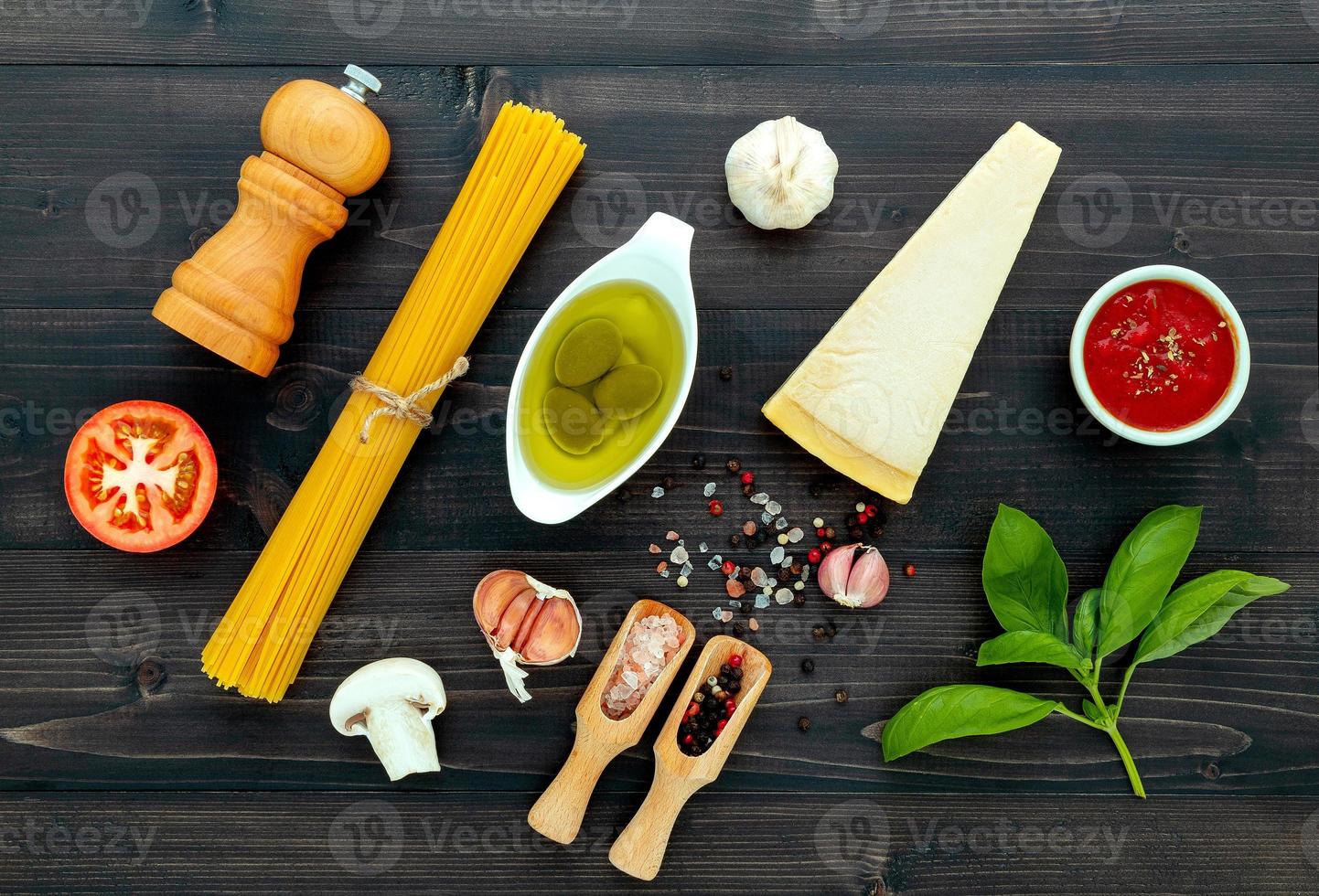 la pasta su fondo di legno nero. pasta italiana gialla con ingredienti. cibo italiano e concetto di menu. foto