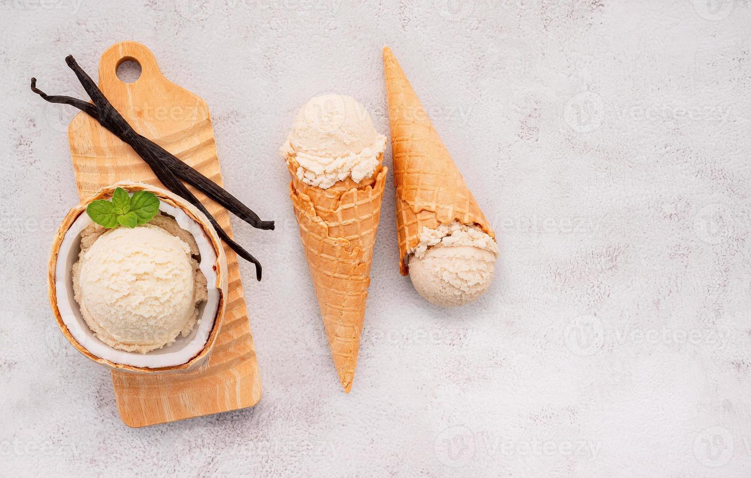 gusti di gelato al cocco a metà della configurazione di cocco su sfondo di pietra bianca. concetto di menu estivo e dolce. foto