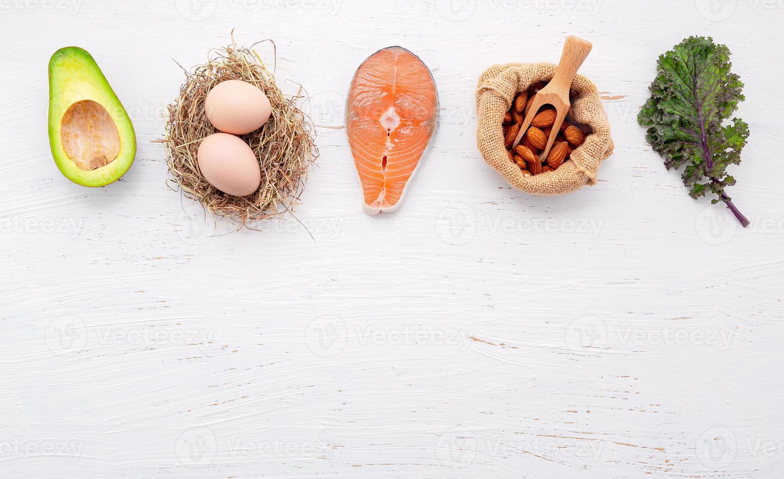 concetto di dieta chetogenica a basso contenuto di carboidrati. ingredienti per la selezione di cibi sani impostati su sfondo bianco di cemento. foto