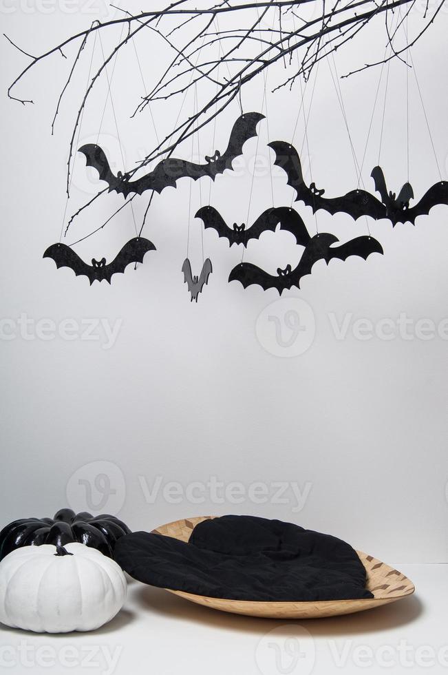 sagome di Halloween con molti pipistrelli neri su un ramo di albero e una zucca su sfondo bianco foto