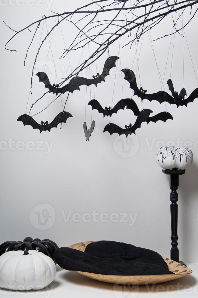 sagome di Halloween con molti pipistrelli neri su un ramo di albero e una zucca su sfondo bianco foto