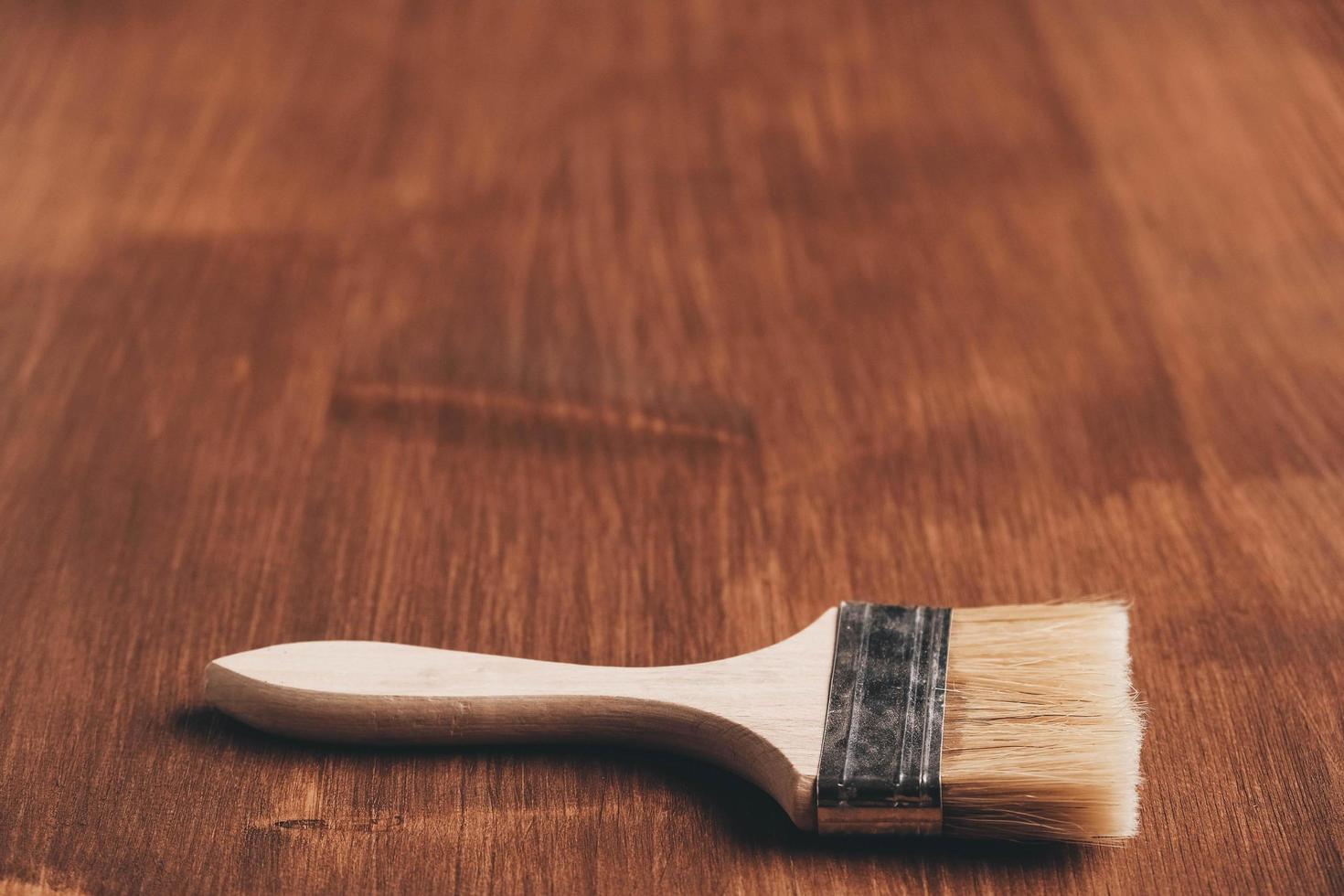 spazzola con manico in legno e setole naturali su sfondo di assi di legno dipinte di marrone foto